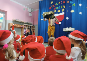 Dzieci oglądaja sztuczkę z latającym stolikiem, którą prezentuje magik