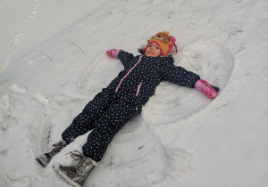 Dziewczynka robi aniołka na śniegu