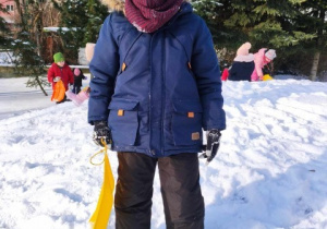 Chłopiec na śniegu z saneczkami