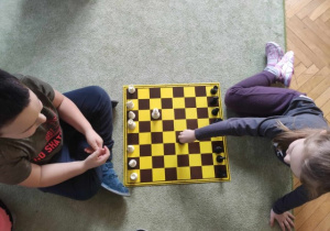 Dzieci ustawiają figury na szachownicy