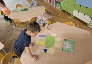 Dzieci ukłądają dinozaury z figur geometrycznych według wzoru