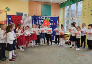 Dzieci z grupy "Stokrotek" trzymając w dłoniach biało- czerwone serca , śpiewają piosenkę.