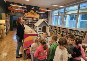 Pani bibliotekarka rozmawia z dziećmi na temat zasad zachowania się w bibliotece.