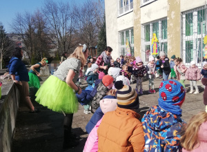 Dzieci w kole ilustrują piosenkę ruchem.