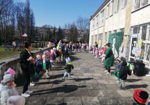 Dzieci tańczą na tarasie, tworząc koło.