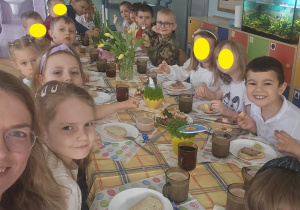 Dzieci pozują do zdjęcia przy świątecznym stole.