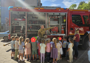 Dzieci stoją przy wozie strażackim oglądają wyposażenie wozu