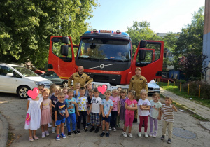 Dzieci stoją przed wozem strażackim