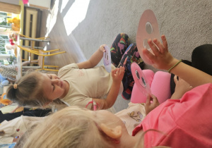 Dziewczynki trzymają w dłoniach kolorowe kropeczki