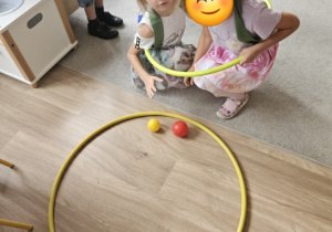 Dziewczynki w hula hop pokonują tor przeszkód