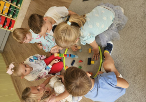 Grupa 6 dzieci układa wieżę z klocków