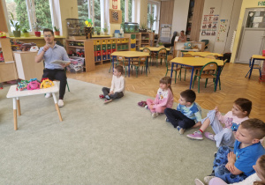 Dzieci słuchają jak Pan psycholog czyta im książkę o emocjach