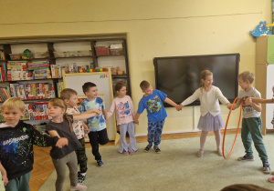 Dzieci przekładają hulahop tak by nie rozłączyć koła