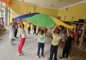 Dzieci unoszą wspólnie chustę