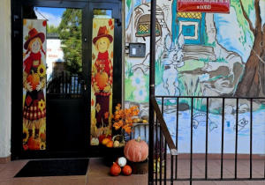 Wejście do przedszkola udekorowane dyniami i jesiennymi dekoracjami