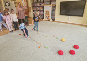 Dzieci pokonują tor przeszkód w parach cały czas trzymając się za ręce