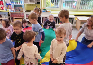 Grupa dzieci bawi się z chustą animacyjną
