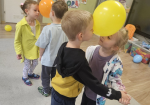 Dzieci tańczą w parach z balonami.