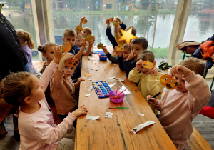 dzieci prezentują wykonane samodzielnie podczas warsztatów drewniane dynie