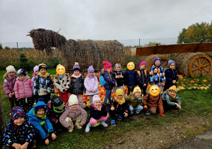 grupa dzieci na tle jesiennej dekoracji z siana i dyń