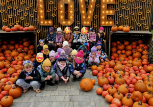 Grupa dzieci na tle dekoracji wykonanej z dyń