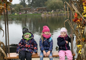 dzieci na huśtawce z jesienną dekoracją