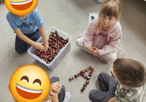 Dzieci ułożyły z kasztanów literę A.