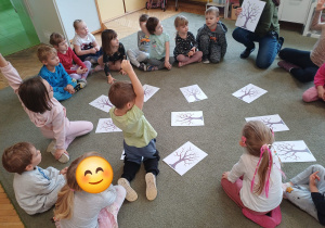 Dzieci podczas zabaw dydaktycznych na dywanie z konturem drzewa