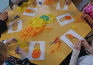 Dzieci bibułą wyklejają kontur gruszki