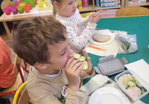 Dzieci zjadają przygotowane przez siebie zdrowe kanapki
