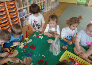 Dzieci bawią się masą solną wykorzystując foremki do wycinania kształtów, wałki itp.