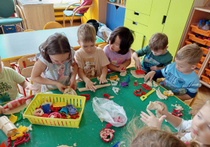 Dzieci bawią się masą solną wykorzystując foremki do wycinania kształtów, wałki itp.