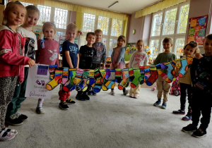 Dzieci z grupy motylków prezentują swoje pokolorowane skarpetki