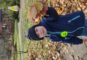 Chłopiec prezentuje swojego skrzata z liści