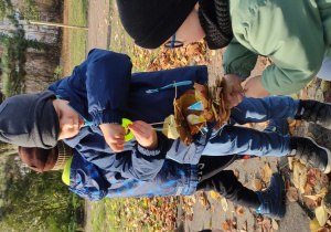 Dzieci nawlekają liście na patyczki