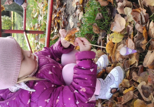 Dziewczynka wykonuje skrzata z lisci