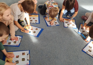 Dzieci wykonują zadanie karta pracy