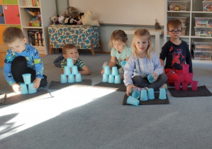 Dzieci konstruują domki wg wzoru z kubeczków