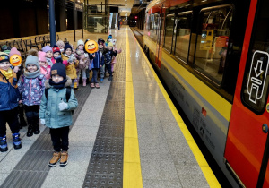 Dzieci stoją na peronie przy pociągu