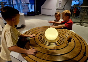 Dzieci oglądają model układu słonecznego