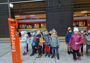 Dzieci stoją na dworcu kolejowym