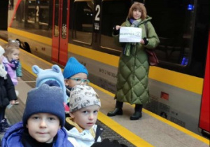 Dzieci stoją na dworcu kolejowym