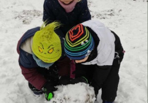 Dzieci budują kulę na bałwanka