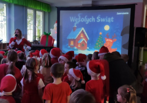 Dzieci ubrane w czerwone stroje tańczą przy świątecznych utworach