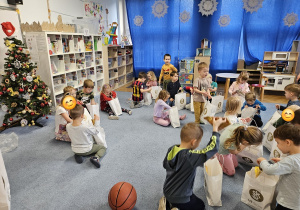 Dzieci z grupy Skrzaty oglądają prezenty które otrzymali od koszykarzy