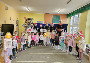 Dzieci z grupy Motylki na wspólnym zdjęciu z koszykarzami, maskotką klubu i choinką