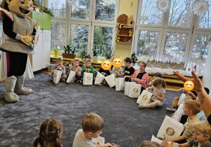 Dzieci z grupy Pszczółki oglądają prezenty które otrzymali od koszykarzy