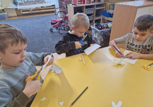 Chłopcy wycinają pierniki z papieru