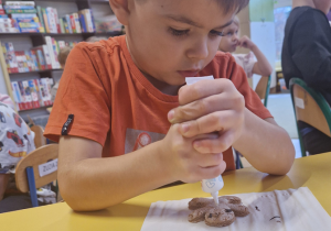 Chłopiec dekoruje pierniczka
