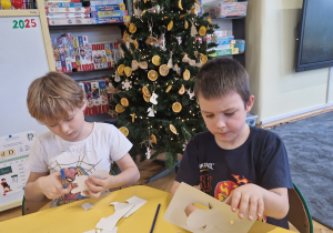 Chłopcy wycinają pierniki z papieru